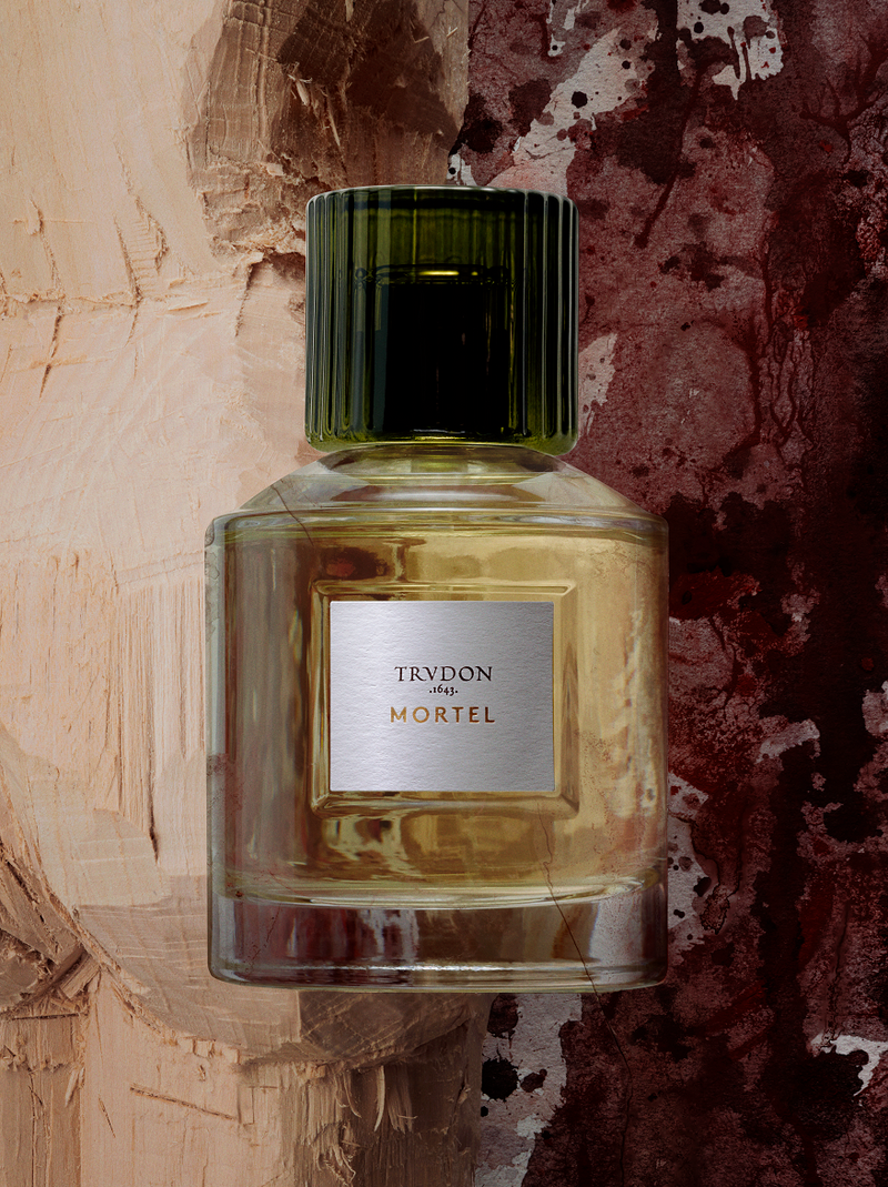 Cire Trudon | Mortel Perfume | Scent Lounge | Lifestyle Image of Perfume Bottle, Peach & Purple Background